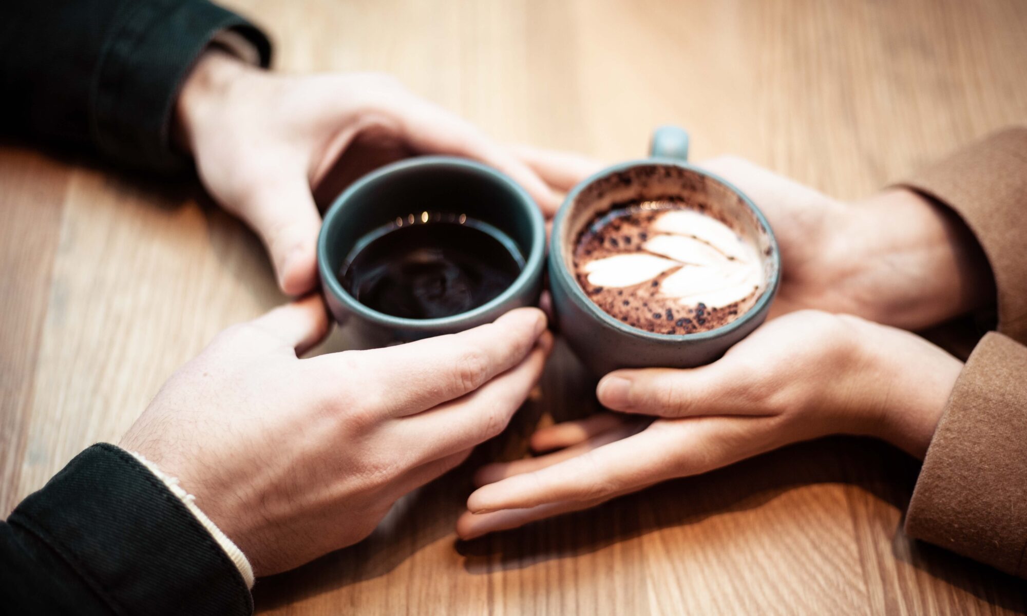 Verschlungene Hände beim Kaffee trinken